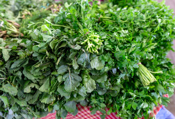 Obraz premium Fresh bunches of green parsley and arugula at a local farmer's market