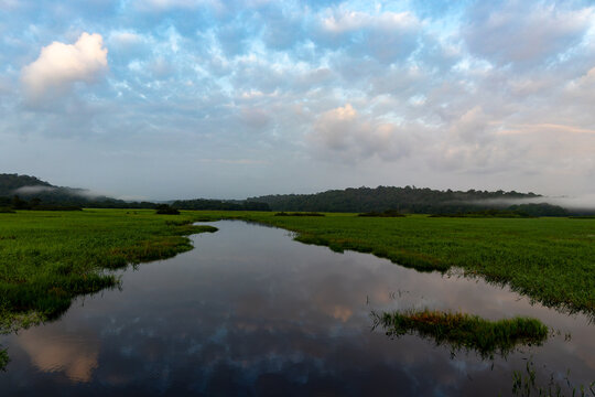 Sunrise and sunset over Kaw wetlands, traditional canoes on calm water, tropical marsh in French Guiana.