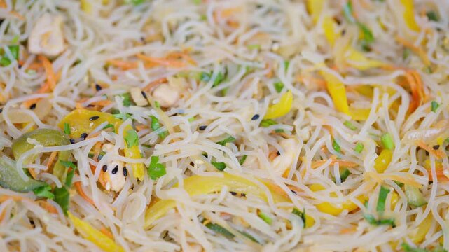 Bright glass noodles with fresh vegetables displayed macro. Detailed macro shot capturing vibrant vegetable glass noodles with sesame seeds and light soy dressing