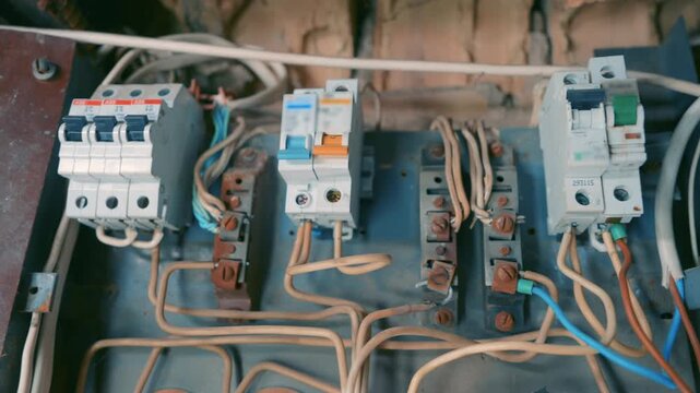 New Circuit Breakers Installed on Old Rusty Electrical Panel | Modern Relays on Aged Fuse Box During Renovation | Close-Up Industrial Wiring Upgrade