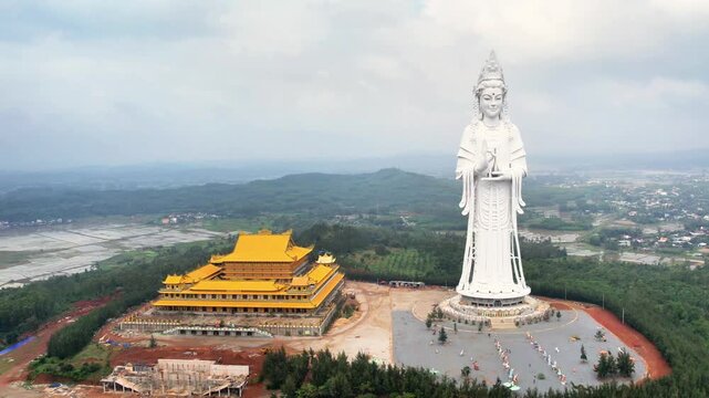 Close-up 4K aerial orbit of the Minh Duc Pagoda complex, showcasing the harmonious layout of the main hall and the giant Buddha statue.