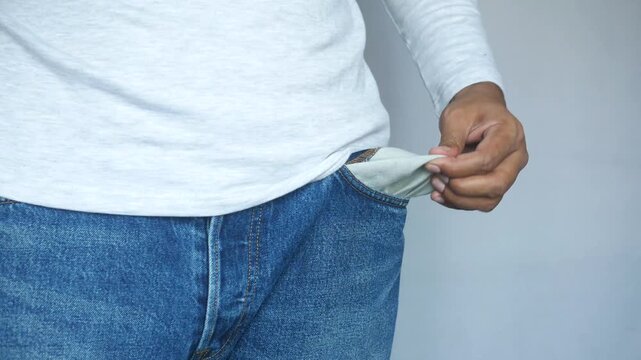 Person turning out empty pockets, showing no money, financial hardship concept