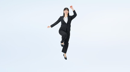 Fototapeta premium ジャンプするスーツの女性ビジネスパーソンの全身写真（切り抜き背景透過PNGも販売しております。↓作成者リンクから「PNG」で検索してください）