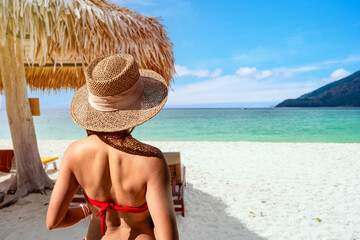 Fototapeta premium Young woman traveler relaxing and enjoying the beautiful tropical white sand beach