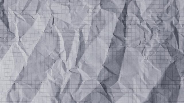 Stop motion of crumpled paper in shades of dusty blue and graphite grey. Hand-colored recycled sheets with organic textures create a dynamic abstract background. 