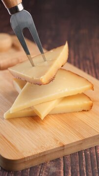 Enjoying cheese on a wooden board with a cheese knife
