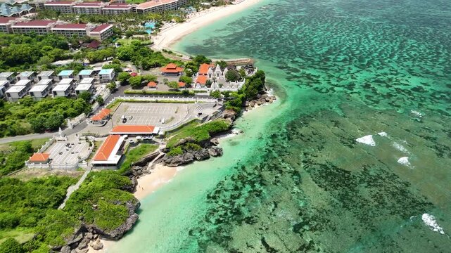 Aerial drone fly-in towards Pura Geger Dalem Pemutih temple on a rocky cliff, Bali, Indonesia