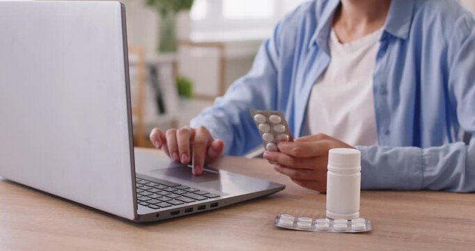 Woman holding blister of medication for online medicine instruction search. Lady with tablets in hand using laptop to read dosage and side effects on medical site, person ordering medicaments