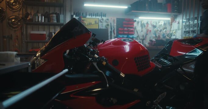 Professional Female Rider Detaching Battery Cables Using Screwdriver In Workshop. Asian Woman Mechanic in Overalls Works on Electrical Components of Red Motorbike. Concept of Smart Garage Lifestyle.