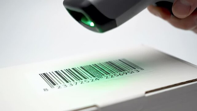 A scanner beam illuminates a barcode on a white cardboard box