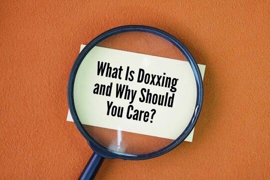 Magnifying glass with the question words What Is Doxxing and Why Should You Care?