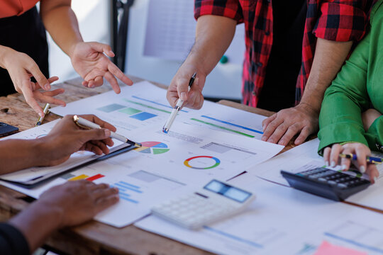 A team of professionals actively engages with business reports, demonstrating collaboration and the analytical approach needed to understand their project's status and results.
