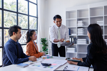 A group of four professionals engaging in a dynamic discussion, showcasing teamwork and...