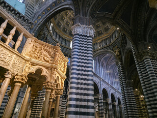Obraz premium Interior of Siena Cathedral featuring Nicola Pisano's Gothic pulpit, striped marble columns and the ornate dome, Tuscany, Italy