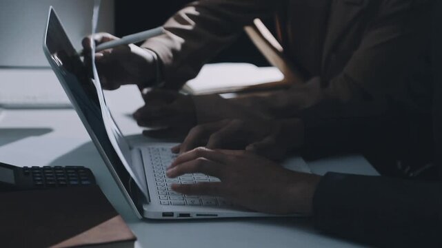 Accountant reviewing printed financial reports at messy office desk with calculator and sticky notes under soft window daylight for audit and corporate finance work