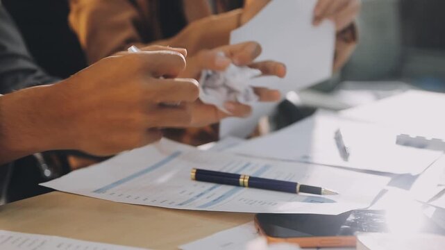 Accountant reviewing printed financial reports at messy office desk with calculator and sticky notes under soft window daylight for audit and corporate finance work