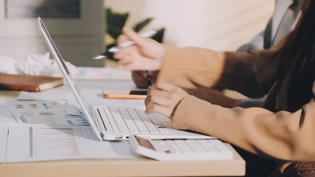 Accountant reviewing printed financial reports at messy office desk with calculator and sticky notes under soft window daylight for audit and corporate finance work
