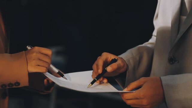 Accountant reviewing printed financial reports at messy office desk with calculator and sticky notes under soft window daylight for audit and corporate finance work