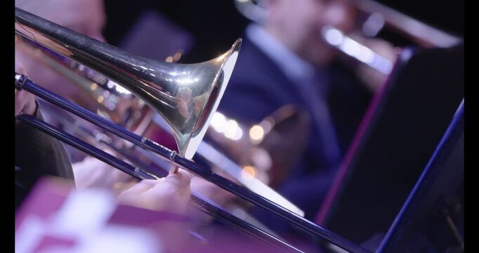 A slow motion video of musicians playing the trombone during a wind ensemble rehearsal. Nr.1
