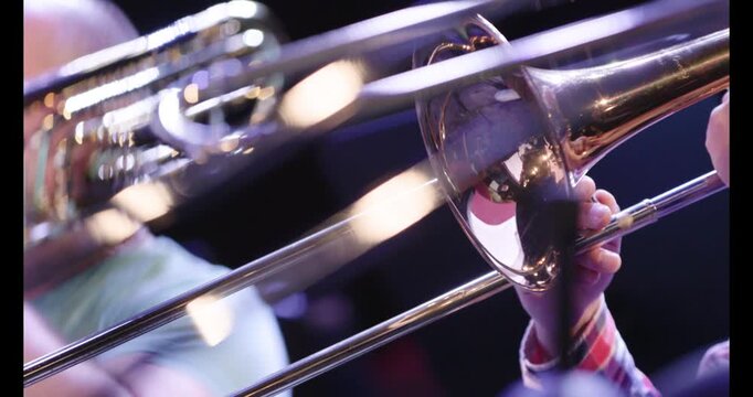 A slow motion video of musicians playing the trombone during a wind ensemble rehearsal. Nr.5