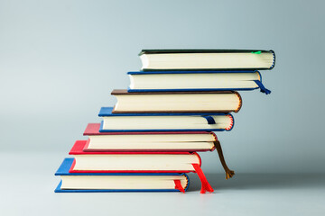 Stack of colorful hardcover books arranged like steps symbolizing learning progress and education