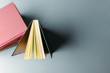 Open hardcover book standing upright with copy space on minimal background © patpitchaya