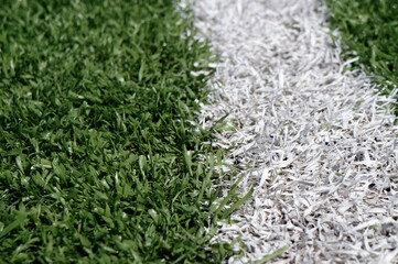 White boundary line on a green artificial turf sports field