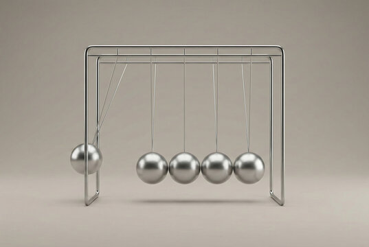 Silver newtons cradle with metal balls hanging on wires demonstrating physics laws of momentum and energy conservation for business leadership balance and office desk concept