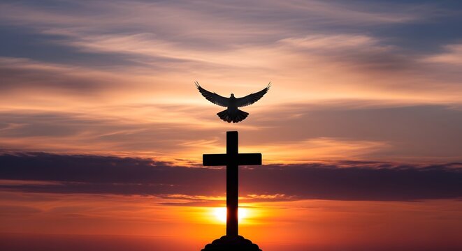 Silhouette of a dove atop a cross at sunset