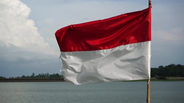The single large red and white Indonesian flag flutters in the strong wind ahead of the 81th Independence Day of the Republic of Indonesia.
