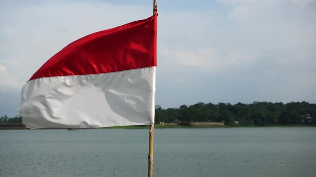 The single large red and white Indonesian flag flutters in the strong wind ahead of the 81th Independence Day of the Republic of Indonesia.