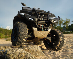 Fototapeta premium A man engages in extreme ATV riding on sand beach early in the morning