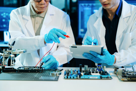 Engineers repairing computer hardware and analyzing data storage systems in a high-tech lab with cybersecurity monitoring, diagnostics, and digital technology