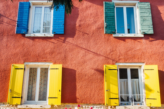 Fa&ccedil;ade de maison color&eacute;e. Mur et fen&ecirc;tres d'une maison de couleurs diff&eacute;rentes. Volets de couleurs sur un ext&eacute;rieur de maison.