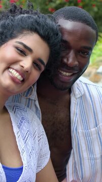 Vertical video: Camera zooming couple leaning closer by pool, wearing crochet coverup for closeup