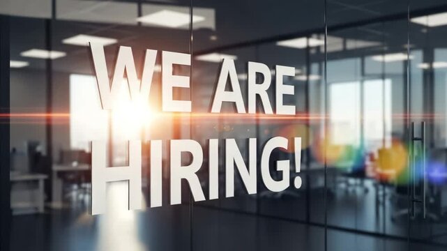 We Are Hiring!" sign on a modern glass office wall, symbolizing new job opportunities, recruitment, and business growth in a professional corporate environment.