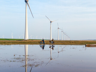 Fototapeta premium Exploring the serene landscape of Urk with wind turbines reflecting in calm waters