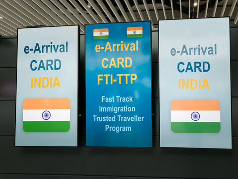 Digital displays at an airport presenting information about the India e Arrival card and the Fast Track Immigration - FTI TTP - program for trusted travellers, streamlining border arrival processes
