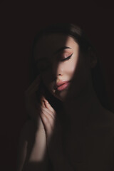 Portrait of attractive girl with healthy clean skin and beautiful make-up. The girl shows her well-groomed skin on her face and neck. Aesthetic cosmetology and makeup concept.