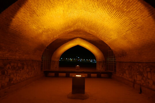 Golden night illumination of the historic Si o se pol bridge featuring iconic arches and Safavid architecture in Isfahan Iran