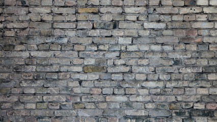 Obraz premium Old brick wall of a building, the photo shows the texture of yellow-brown bricks of the building's facade