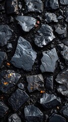 Abstract background texture of dark, wet obsidian or basalt rocks with subtle orange mineral flecks.