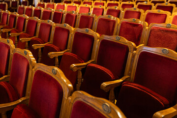 Fototapeta premium Rows of Classic Red Velvet Theater Seats with Wooden Armrests