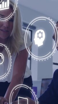 Vertical video: Lead leaning pointing at tab showing HUD icons over team while man using tech data