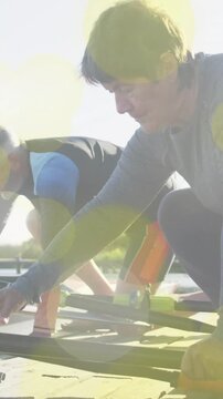 Vertical video: Post-dock female rower and male mate aligning oars and checking rigging for rowing