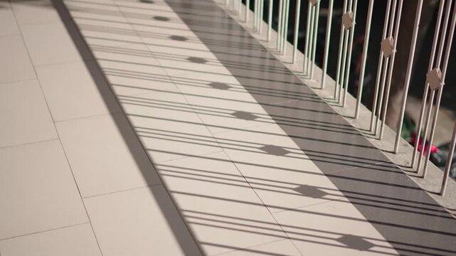 Sunlight casting shadows on wooden deck with railing minimal background