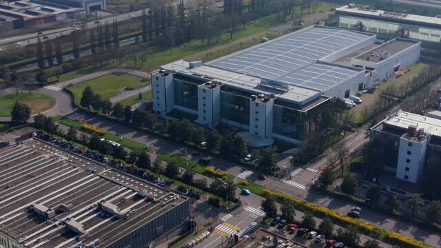 Industrial Park Aerial View: An expansive aerial view showcases a modern industrial park with sleek, contemporary buildings and vast parking lots, Assago, Milan