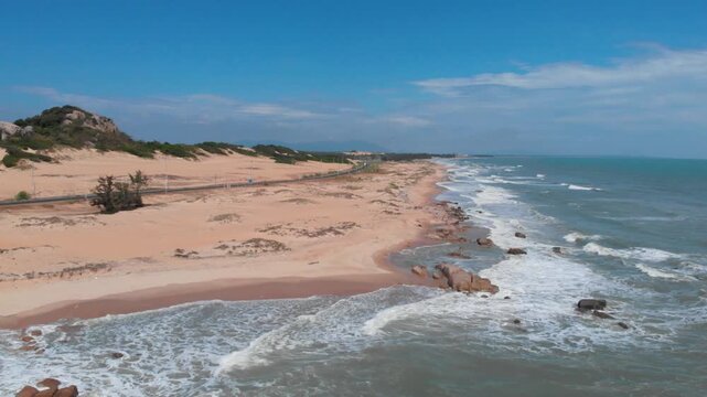 Aerial view of sandy coastline and ocean waves near Phan Thiet Vietnam drone footage
