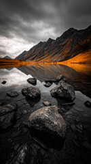 Mountains and rocks reflect in the water of a lake during the day in a valley surrounded by hills in autumn