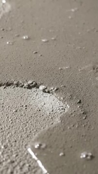 Dynamic shot capturing the visual transformation of a blooming concrete surface as a clear protective sealant or curing compound is evenly sprayed across it. time-lapse/transformation